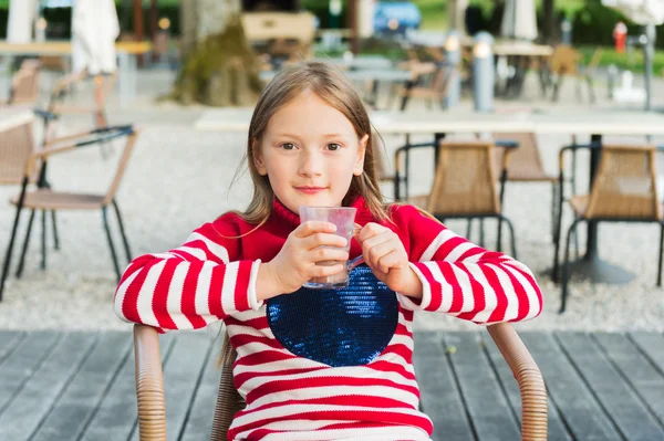 Cute little girl drinking hot chocolate in a cafe — Stock Photo, Image