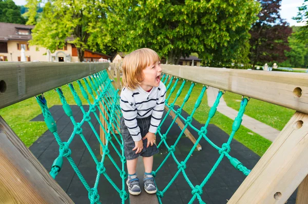 Adorável pouco por se divertir no parque infantil — Fotografia de Stock