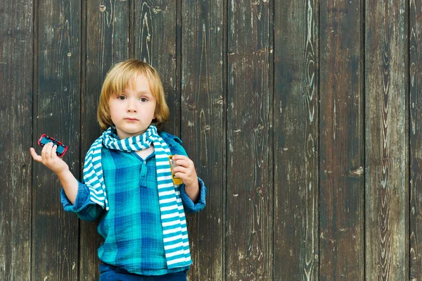 Retrato de moda de um menino loiro bonito contra fundo de madeira, vestindo camisa de esmeralda e cachecol — Fotografia de Stock