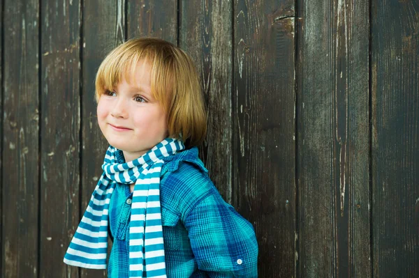 Модный портрет симпатичного маленького блондина на деревянном фоне, в изумрудной рубашке и шарфе — стоковое фото