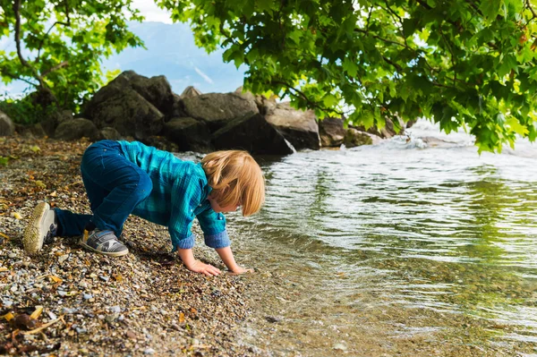 Petit garçon jouant au bord du lac — Photo