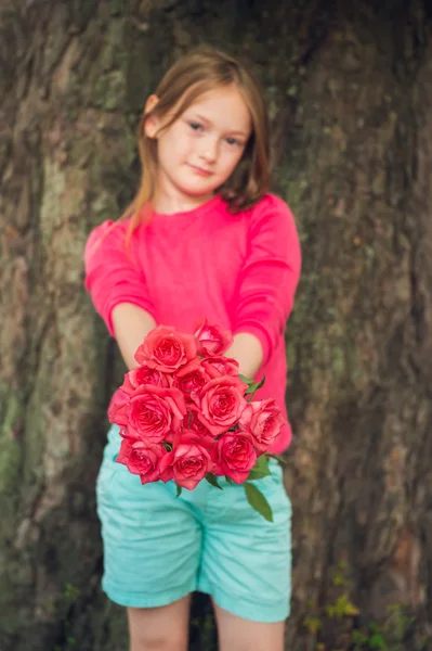 Cute little girl giving beautiful bouquet of bright pink roses — Stok fotoğraf