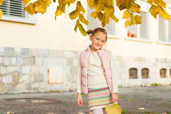 Herbstporträt eines entzückenden kleinen Mädchens in rosa Weste und warmem Strickrock — Stockfoto