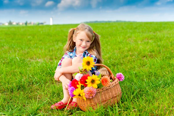 Retrato ao ar livre de adorável menina brincando com flores no campo no campo em um dia ensolarado agradável — Fotografia de Stock
