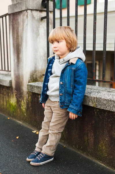 Fashion portrait of adorable little boy wearing denim jacket, beige corduroy trousers, gray sweatshirt and blue shoes — Stock Photo, Image