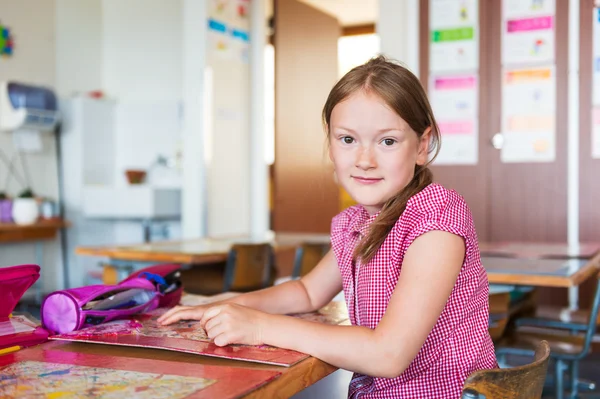 Retrato interno de uma menina bonita em uma sala de aula — Fotografia de Stock