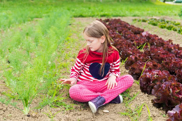 Cute little girl playing in a garden — Stockfoto