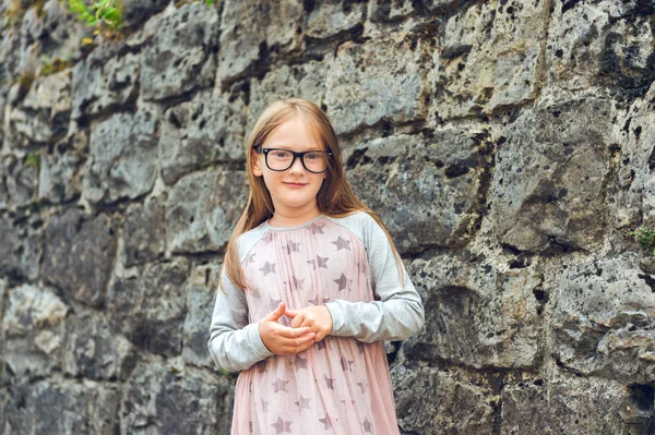 Outdoor portrait of a cute little girl in a city, wearing eyeglasses and dress — Stock Photo, Image