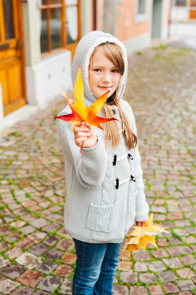 Kid girl playing with autumn yellow leaves outdoors — Stok fotoğraf