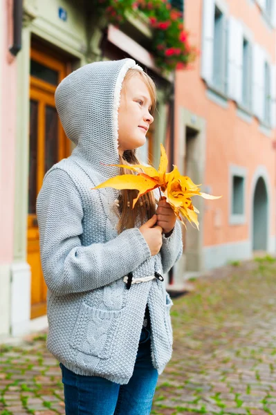 Kid girl playing with autumn yellow leaves outdoors — Stok fotoğraf