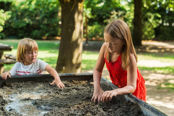 Cute kids playing in a sandbox — Stock Photo, Image