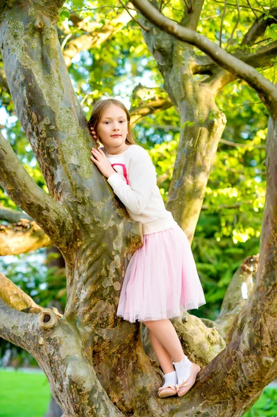 Carina bambina che gioca nel parco, arrampicata sull'albero — Foto Stock