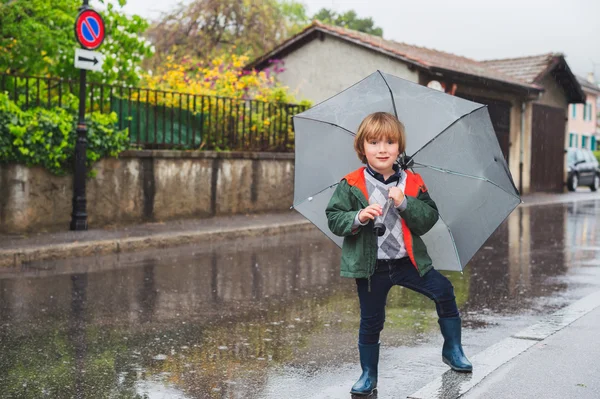 Outdoor portrait of adorable little blond boy with umbrella under the rain — Stock Photo, Image