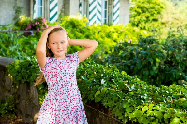 Ritratto all'aperto di una bambina carina che gioca in un giardino in una bella giornata di sole — Foto Stock