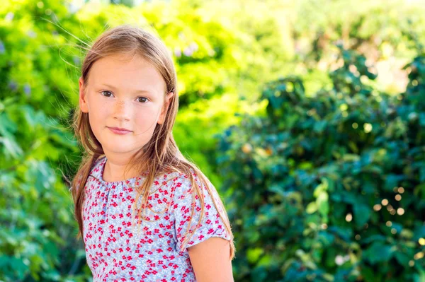 Ritratto all'aperto di una bambina carina che gioca in un giardino in una bella giornata di sole — Foto Stock