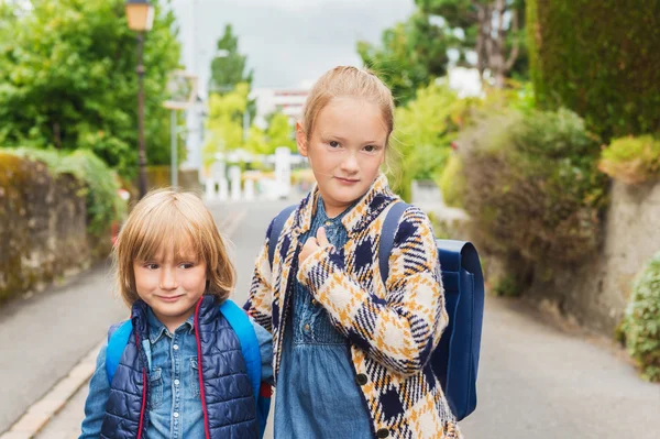 Lindos niños con mochilas caminando a la escuela —  Fotos de Stock