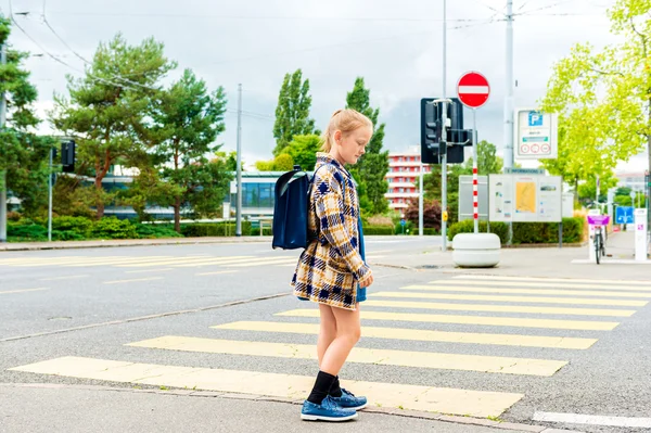 Niedliches kleines Mädchen von 7 Jahren Mädchen zu Fuß zur Schule, überquert die Straße in einer Stadt — Stockfoto