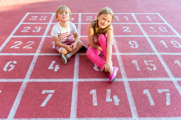 Twee schattige kinderen rusten op het schoolplein — Stockfoto