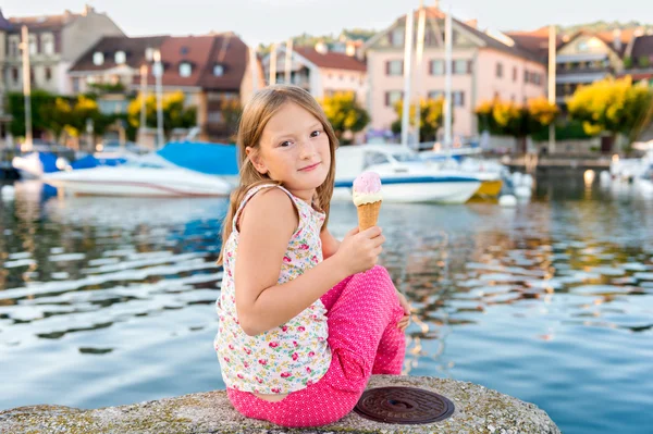 Retrato ao ar livre de uma menina bonito, comer sorvete, descansando junto ao lago — Fotografia de Stock