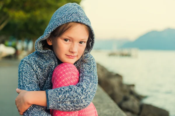 Close up portrait of a cute little girl of 8 years old at sunset, resting by the lake — Zdjęcie stockowe