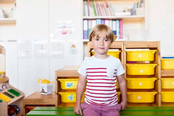 Retrato interno de um menino bonito em uma sala de aula — Fotografia de Stock