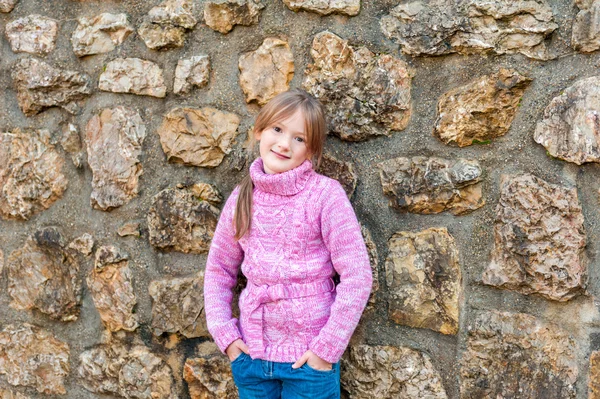 Außenporträt eines entzückenden kleinen Mädchens in rosa Pullover — Stockfoto