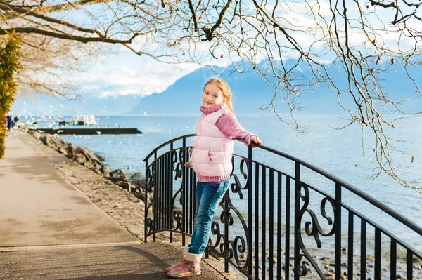 Açık pembe ceket ve sıcak bot giyen sevimli küçük kız portresi — Stok fotoğraf