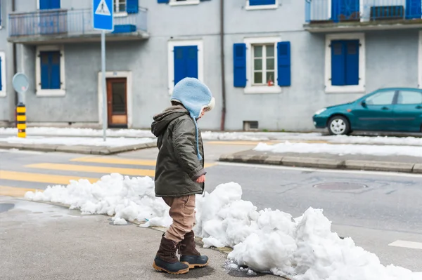 Söt liten småbarn pojke leker med snö utomhus, gå av vägen, bär jackor och stövlar — Stockfoto