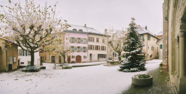 Karların altında süslü Noel ağacı olan şehir meydanı.