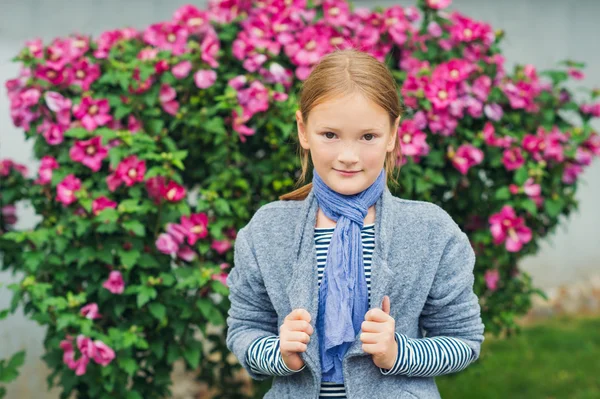 Utomhus porträtt av en söt liten flicka klädd i grå kappa — Stockfoto
