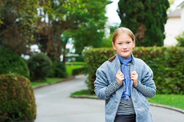 Ritratto all'aperto di una graziosa bambina che indossa un cappotto grigio — Foto Stock