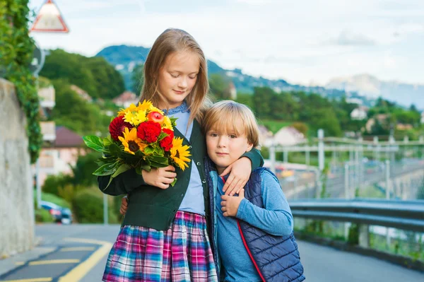 Outdoor portrait of a cute little kids with beautiful bouquet of flowers — Stock Photo, Image