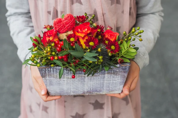 Hermoso ramo de flores de color rojo brillante sosteniendo por las manos del niño — Foto de Stock