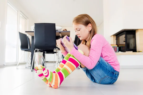 Adorable petite fille jouant sur une tablette numérique — Photo