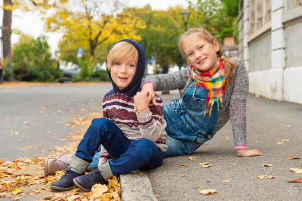 Herbstporträt von 2 entzückenden Kindern in einer Stadt, die warme Pullover und Jeans tragen — Stockfoto