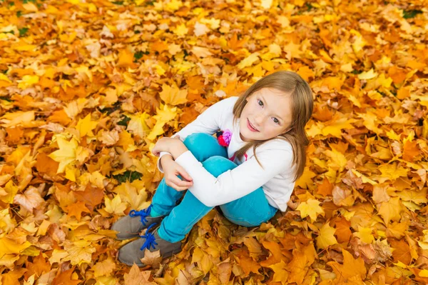 Portret jesieni cute dziewczynka 8 lat, grając z żółtymi liśćmi w parku — Zdjęcie stockowe