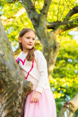 Ağaca tırmanma parkta oynayan sevimli küçük kız