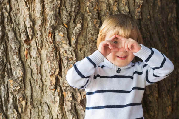 4 χρονών ξανθιά καυκάσιος αγοράκι μπροστά από μια παλιά και μαζική δέντρο που προσποιείται να τραβήξετε μια φωτογραφία με τα χέρια του — Φωτογραφία Αρχείου