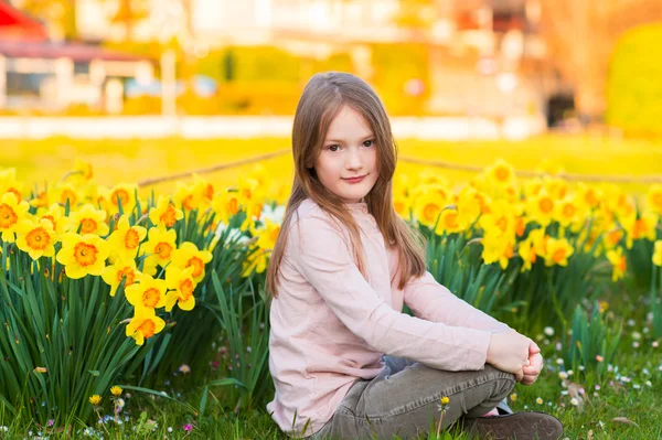 Entzückendes kleines Mädchen spielt bei Sonnenuntergang mit Blumen im Park — Stockfoto