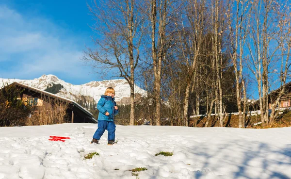 Mignon petit garçon jouant à l'extérieur en hiver — Photo