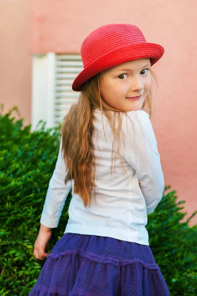 Portrait extérieur d'une mignonne petite fille de 5-6 ans portant un chapeau rouge — Photo