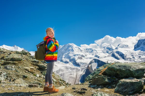 Menina bonito vestindo casaco colorido arco-íris brilhante e botas bege, descansando em montanhas, Suíça — Fotografia de Stock