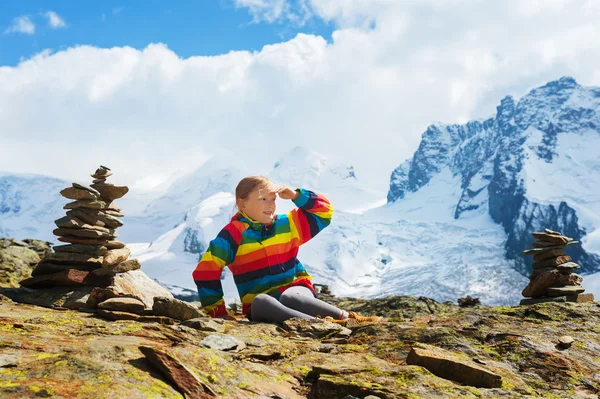 Χαριτωμένο μικρό κορίτσι που φοράει φωτεινό ουράνιο τόξο χρώμα παλτό και μπεζ μπότες, που αναπαύεται στα βουνά, Ελβετία — Φωτογραφία Αρχείου
