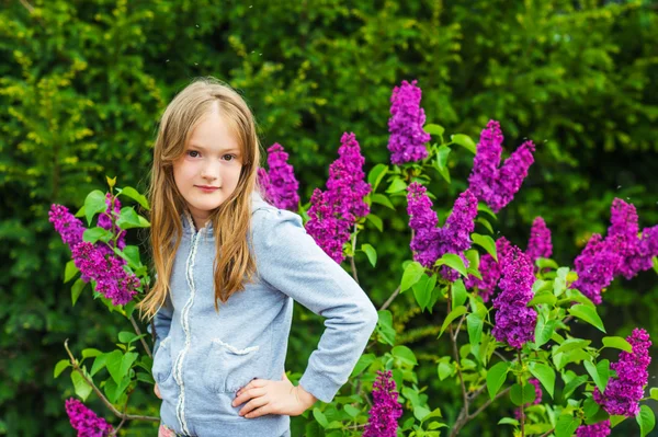 Venkovní portrét roztomilá holčička, proti nádherné Lila na pěkný jarní den — Stock fotografie