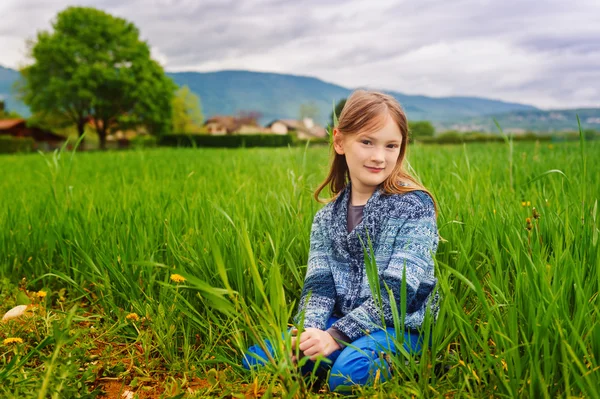 Retrato de moda de menina bonito de 7 anos, vestindo calças azuis e jaqueta de malha — Fotografia de Stock