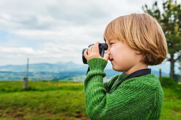 Cute little boy taking pictures with a camera — Stock Photo, Image