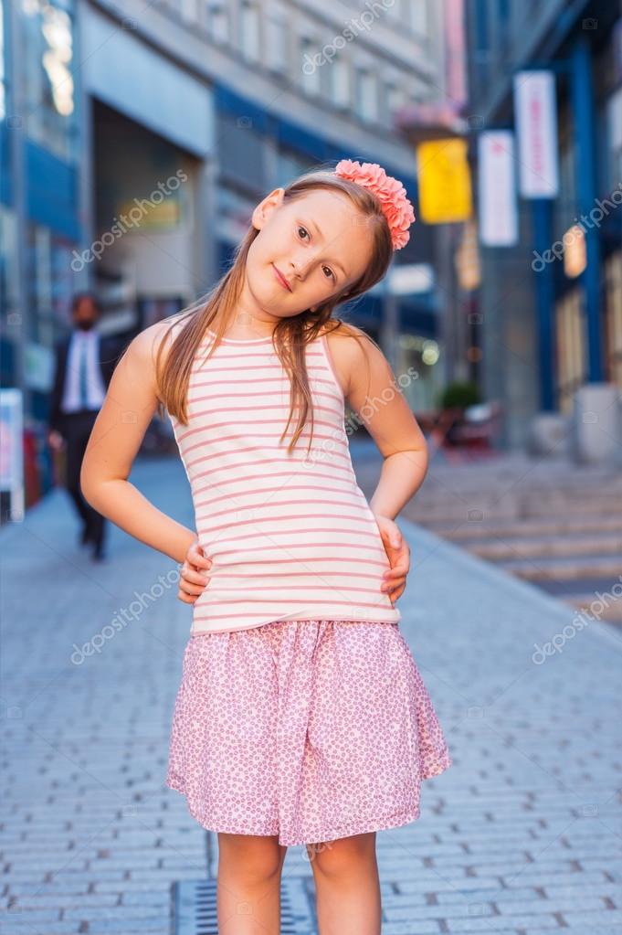 Outdoor fashion portrait of a cute little girl of 7-8 years old