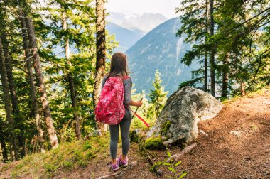 Cute little girl hiking in swiss Alps, admire amazing view