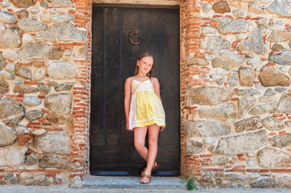 Outdoor fashion portrait of a cute little girl wearing yellow dress — Stockfoto