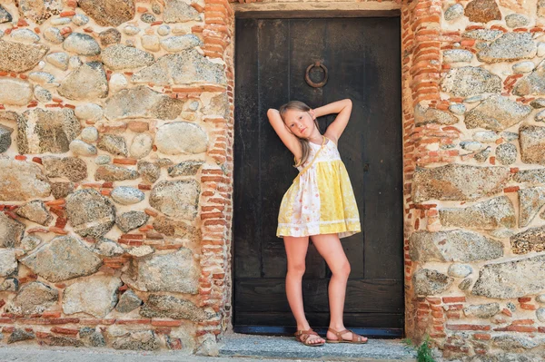 Outdoor fashion portrait of a cute little girl wearing yellow dress — Stock fotografie